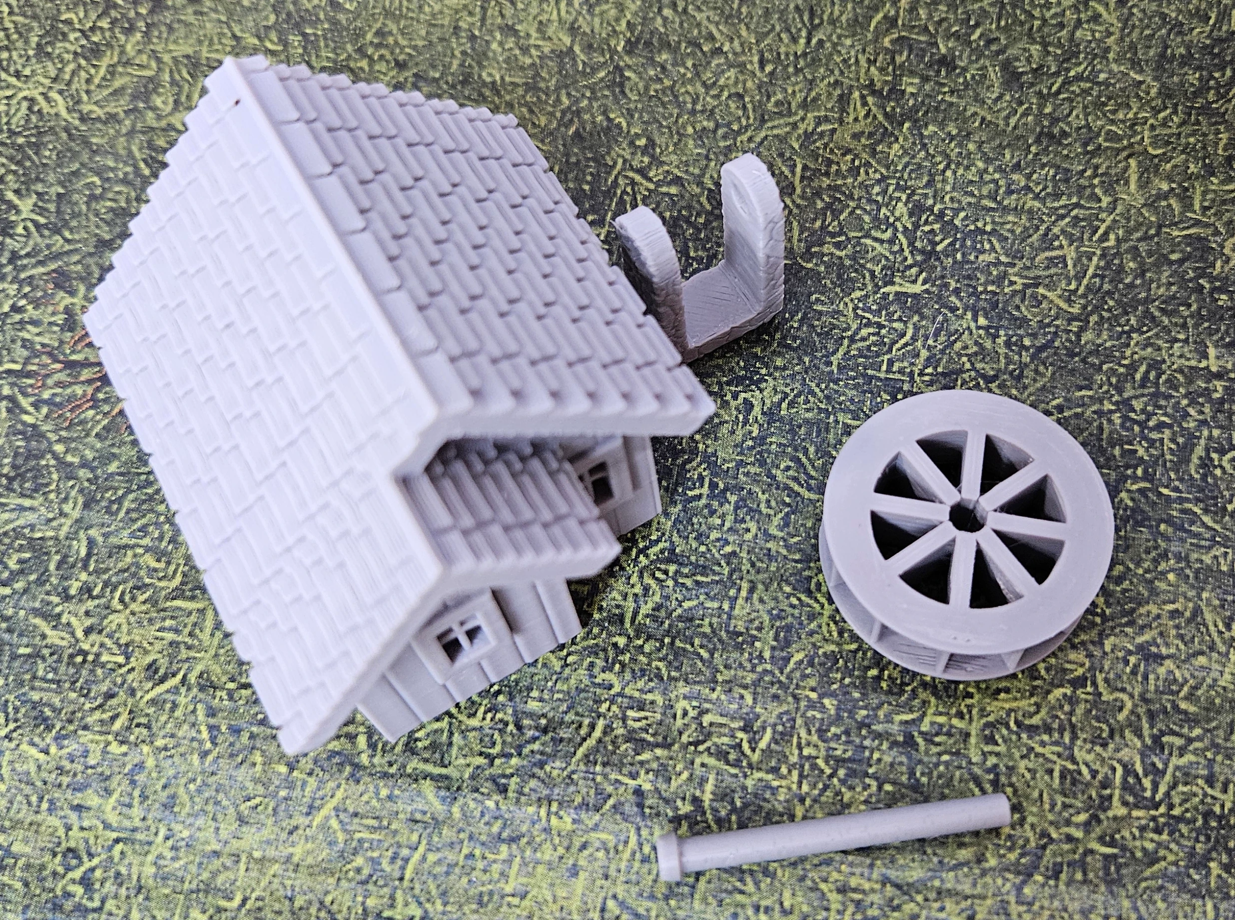 Kit parts view of HO scale waterwheel with small building